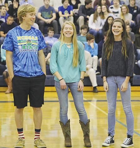 Sophomore Skylar Stultz (from left), junior Hailey Schreyer and sophomore Alex Rodman get a round of applause in the middle of the gym during First Flight’s winter sports pep rally.The trio earned spots in the indoor track championships. PHOTO BY DEA CELAJ/NIGHTHAWK NEWS