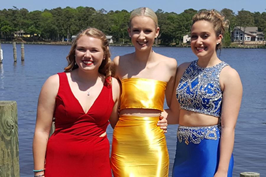 Victoria Hobbs poses for prom photos in her homemade dress alongside Brittany Kusina (left) and Alex Crum (right).