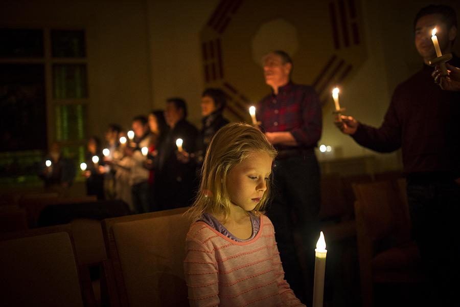 Sophia Jenson, 7, holds an electric candle and sings 'Silent Night' with other attendees of the Christmas Eve candlelight service in Linden Hills, Minn. Photo by Aaron Lavinsky/Minneapolis Star Tribune/TNS