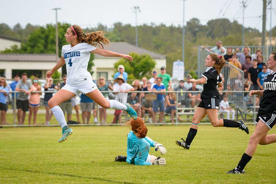 Sophomore Nicole York leaps gracefully over the keeper on her way toward a goal against Clinton in the fourth round of the playoffs. PHOTO BY AARON JENNINGS/Shooters at the Beach/Special to Nighthawk News