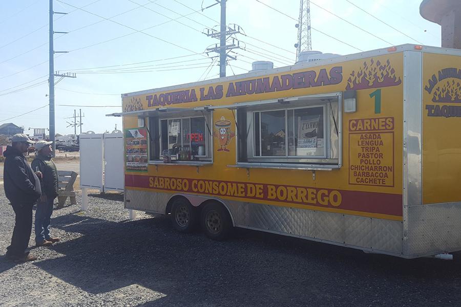 Locals scan the menu at Taqueria Las Ahumaderas food truck outside StringWrays in Rodanthe. PHOTO BY THERESA HONEYCUTT/Special to Nighthawk News