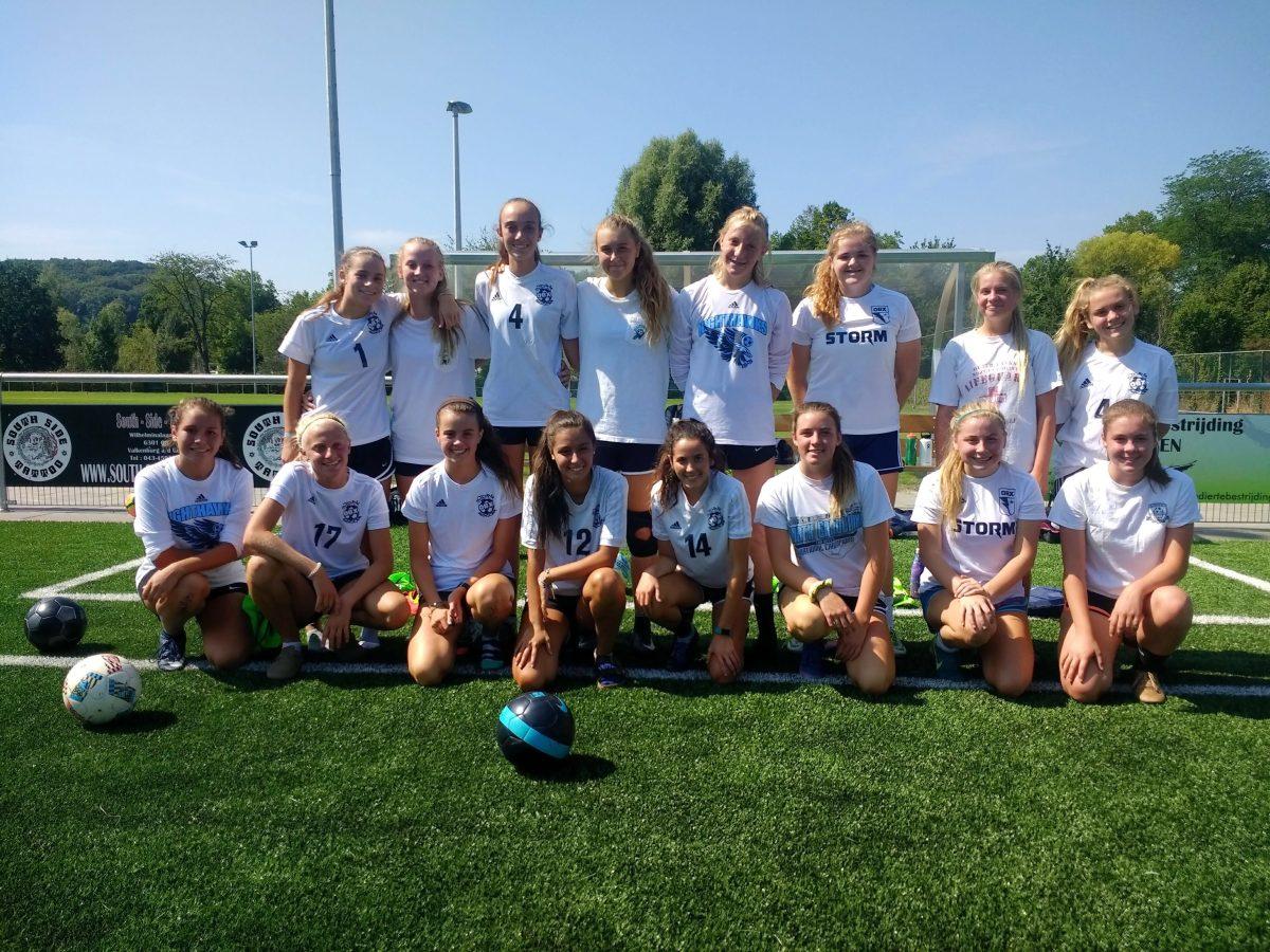 The Storm soccer team poses in front of the field in Europe.