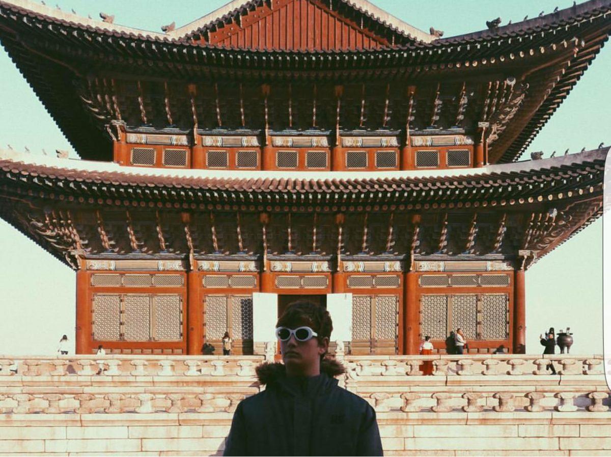 Senior Adam Livingston stands in front of a Korean pagoda with his 'clout goggles.'