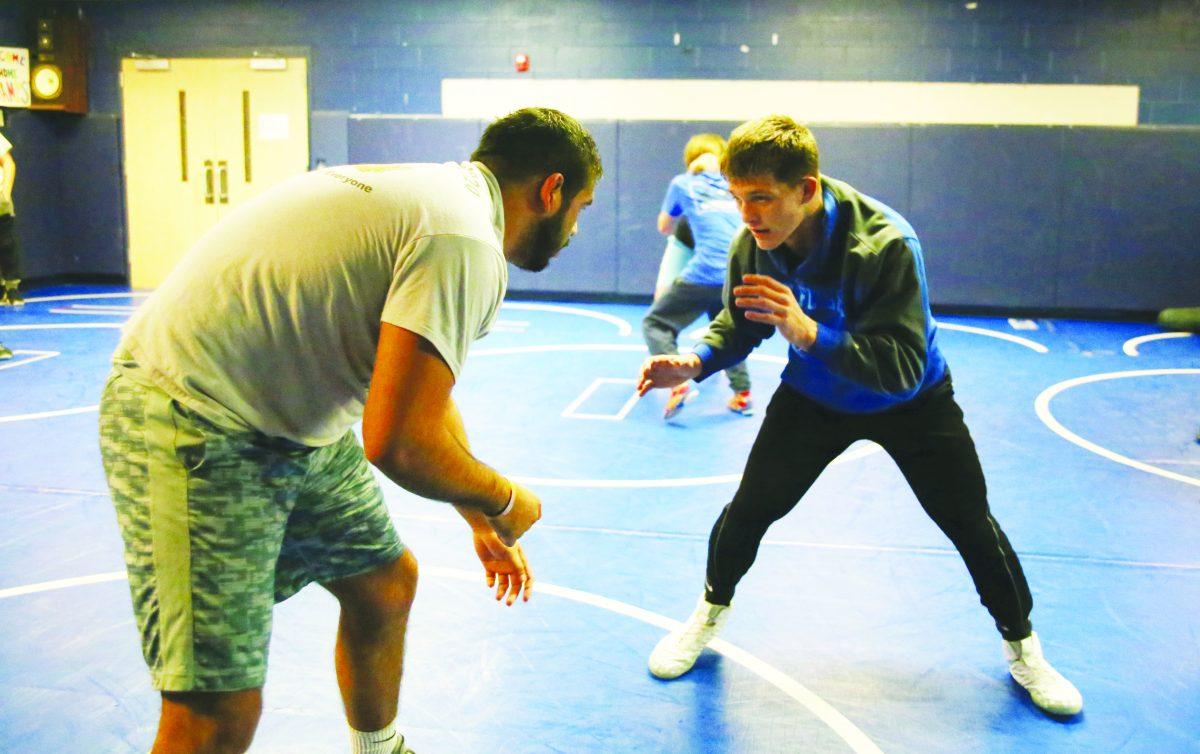 Freshman Jack Hawbaker (right) tangles with alumnus Carlos Martinez during a recent practice. Hawbaker retook eighth-grade classes to dedicate training time ti wrestling and enter high school with the Class of 2022 in the hopes of becoming the school's next standout wrestler. PHOTO BY BEN TRAN / Nighthawk News
