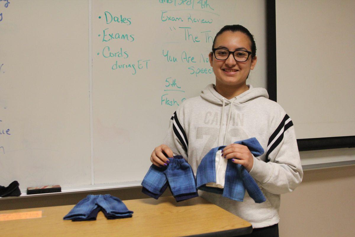 Senior Stephanie Munguia Flores presents her senior project on school uniforms and proudly displays her product: scaled uniforms, which she sewed herself. 
