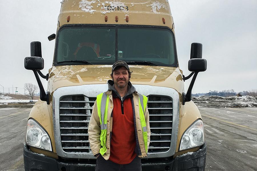 Ian Godwin takes a break from driving as he poses next to his Freightline International 18-wheeler. He describes his driving experience as 'mind-numbing' yet meditative. PHOTO SUBMITTED BY IAN GODWIN