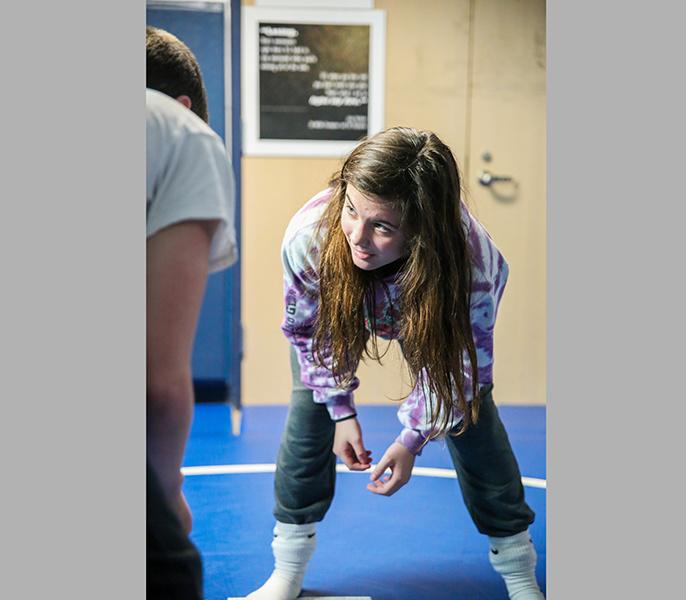 Freshman Reagan Riddick eyes her opponent in the wrestling room during a recent practice. Every match, she grapples with competitors and fans alike questioning her talent on the mat.PHOTO BY TAYLOR NEWTON/Nighthawk News